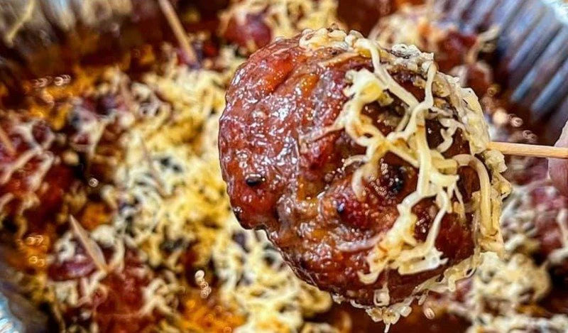 Meatballs covered in cheese and BBQ sauce, perfect for big game BBQ sauce lovers and game-day gatherings.