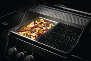 Stainless steel grilling topper on a grill with mixed vegetables cooking.