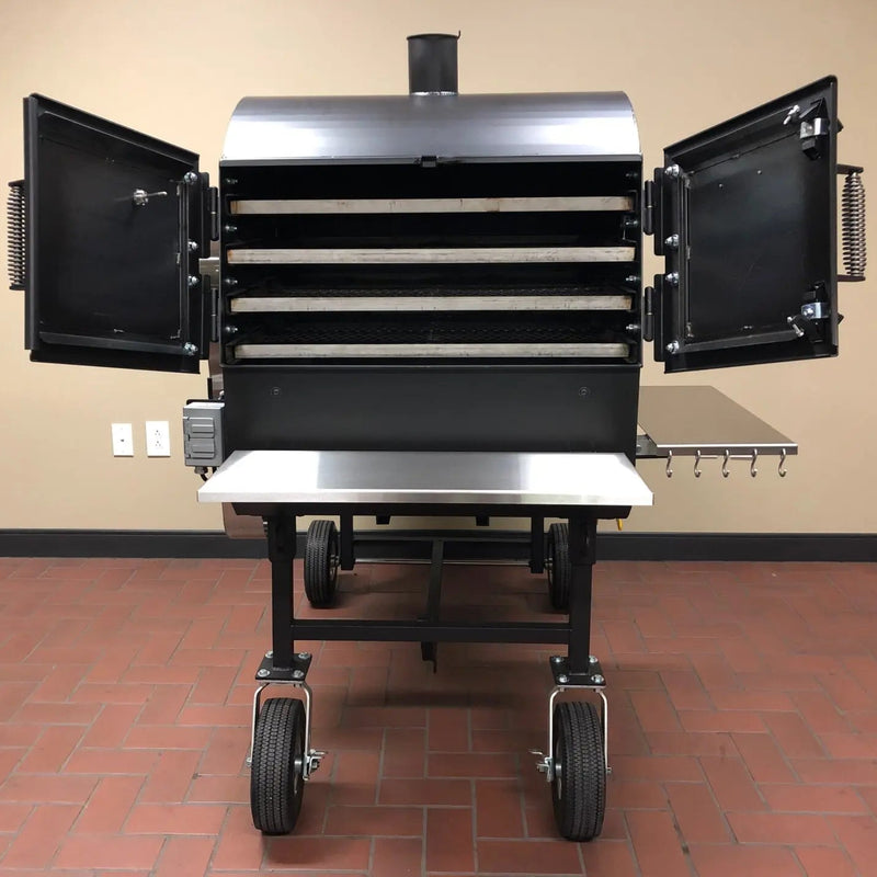 Black barbecue smoker with open doors on a red brick floor.