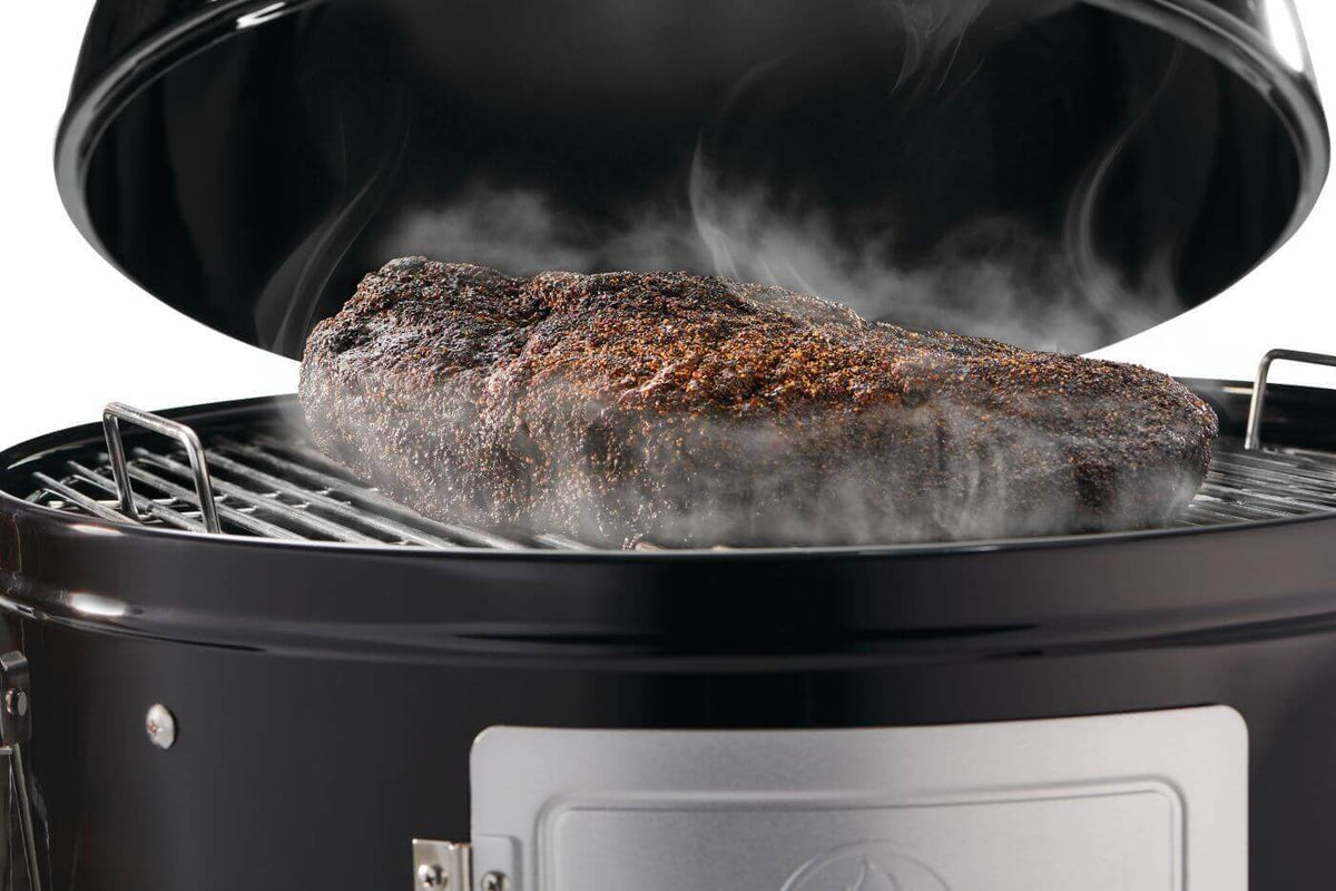 Smoky brisket cooking in Napoleon Grills Apollo 18 charcoal water smoker with lid open.