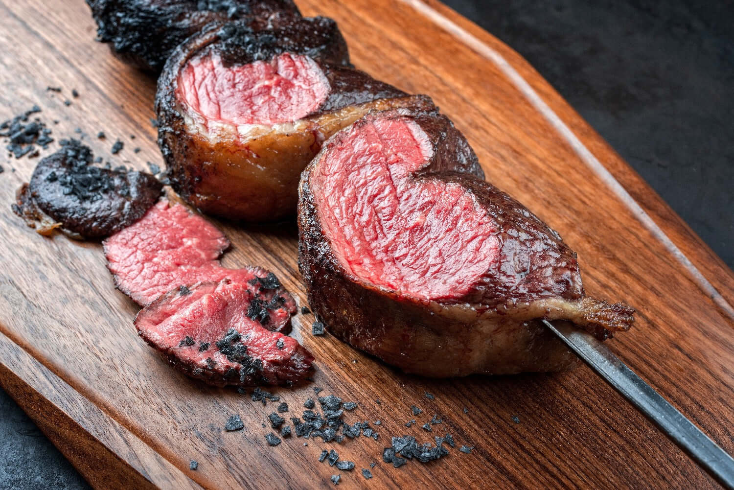 Certified Angus Beef Picanha steak sliced on a wooden board, showcasing its rich marbling and tenderness.