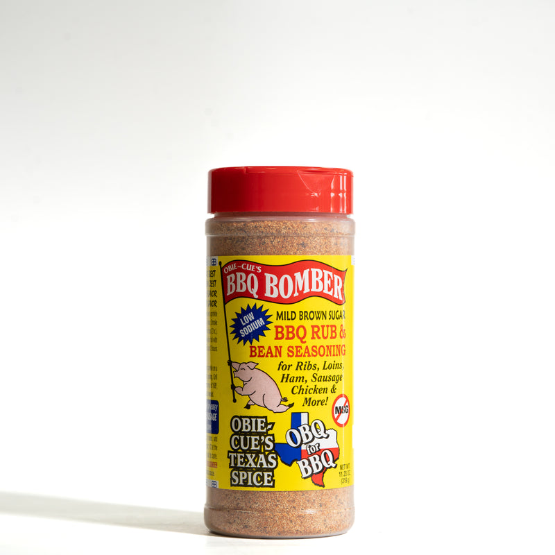A bottle of Obie-Cue's BBQ Bomber Mild Brown Sugar BBQ Rub & Bean Seasoning, featuring a bright red cap and a yellow label with red and blue text, set against a plain white background.