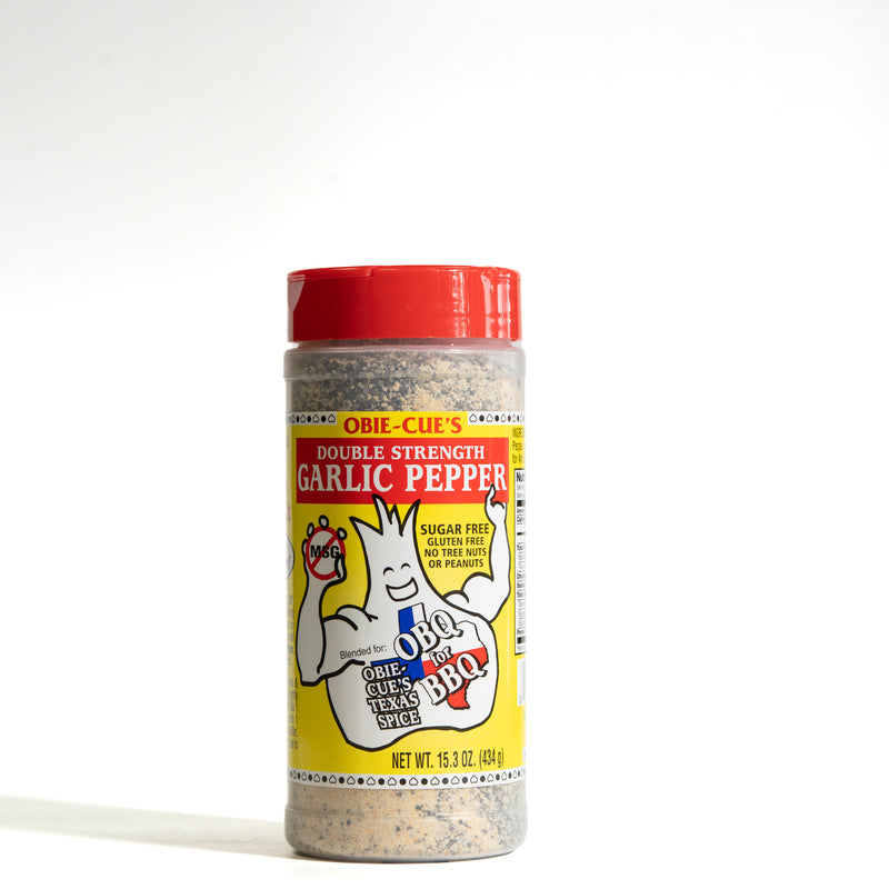 A 16 oz plastic shaker bottle of Obi-Cue's Double Strength Garlic Pepper seasoning, featuring a red lid and a yellow label with the Obi-Cue's mascot, on a white background.