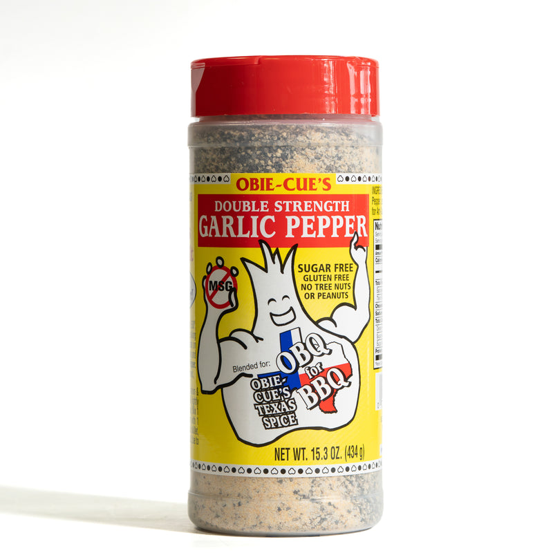 A bottle of Obie-Cue's Double Strength Garlic Pepper seasoning, featuring a bright red cap and a yellow label with the brand's mascot, on a white background.