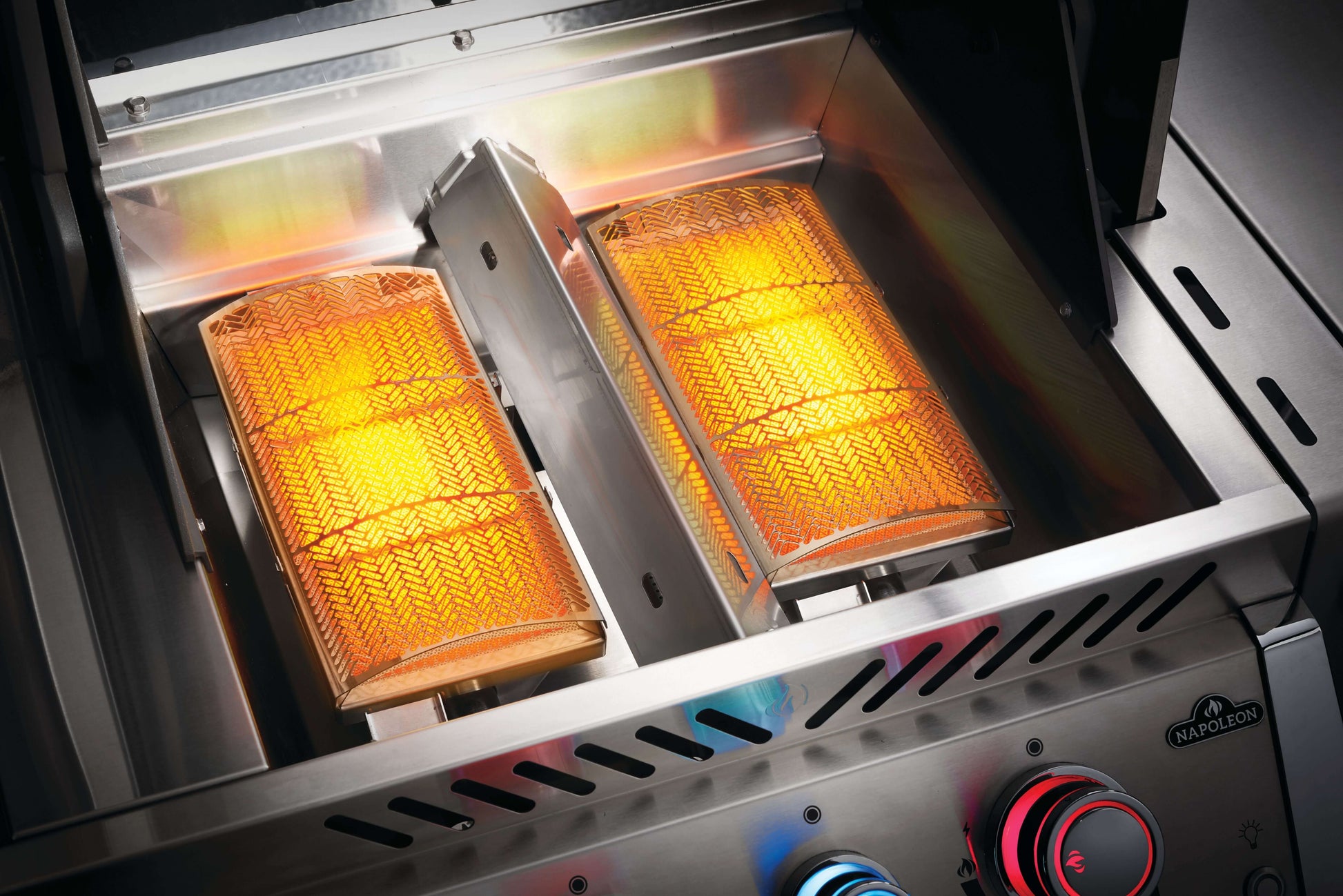 Napoleon Prestige PRO 825 gas grill infrared burners glowing with orange heat.