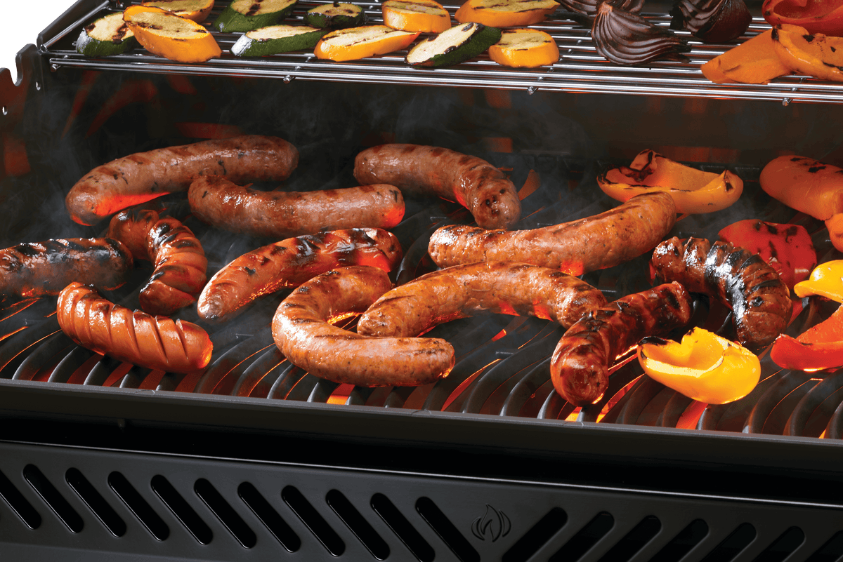 Grilling sausages and veggies on Napoleon Rogue PRO 625 grill, showcasing delicious outdoor cooking.