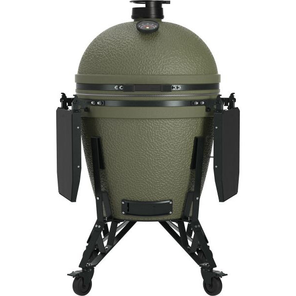 An olive green ceramic kamado grill on a black metal stand with side wings and wheels, shown against a plain white background.